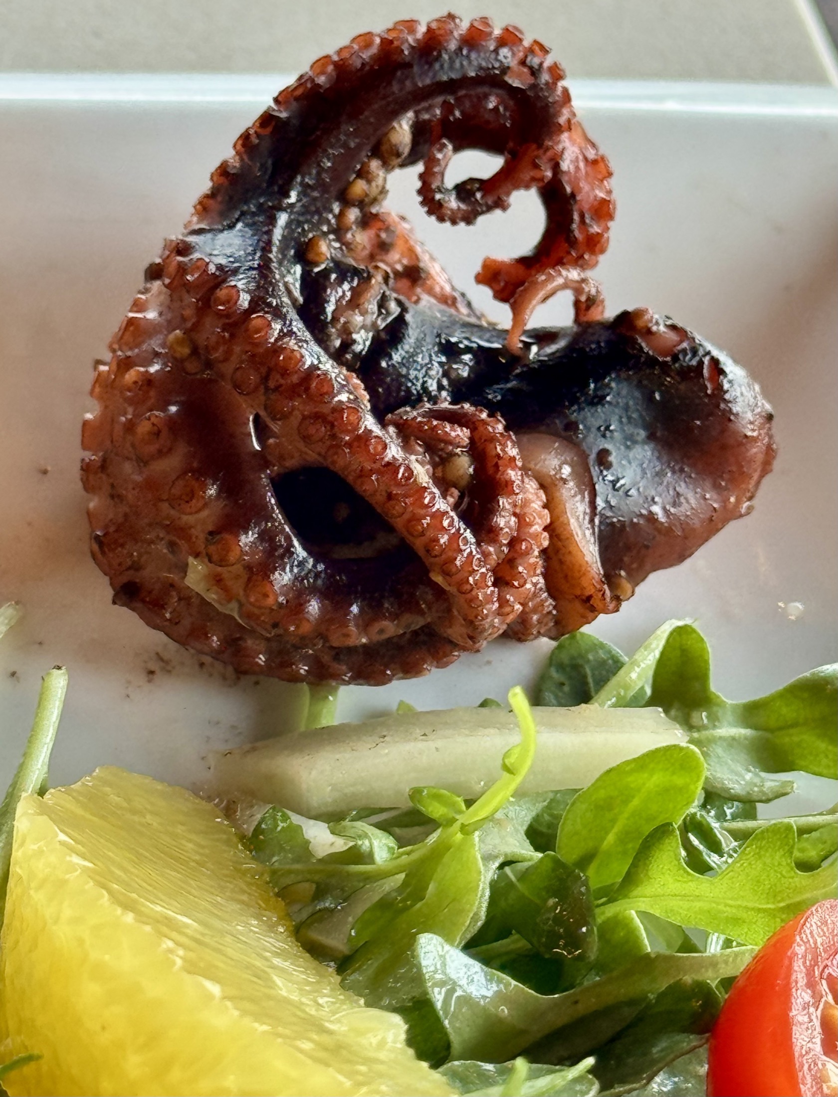Grilled octopus with lemon and greens